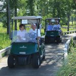 Foursome driving golf carts on path