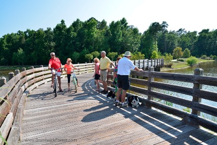 People walking and riding bikes on boardwalk