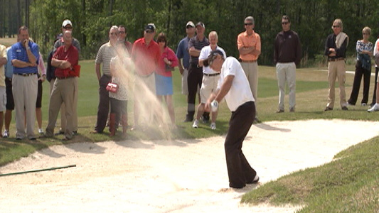 Golfer chipping out of the bunker