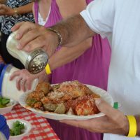 Man adding parmesan cheese to his food