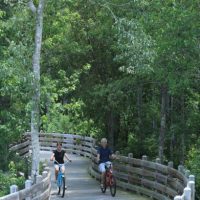 Couple riding their bikes over a bridge