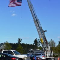 Close up of American flag raised on a fire truck ladder