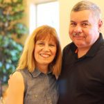 A couple smiling inside a home.