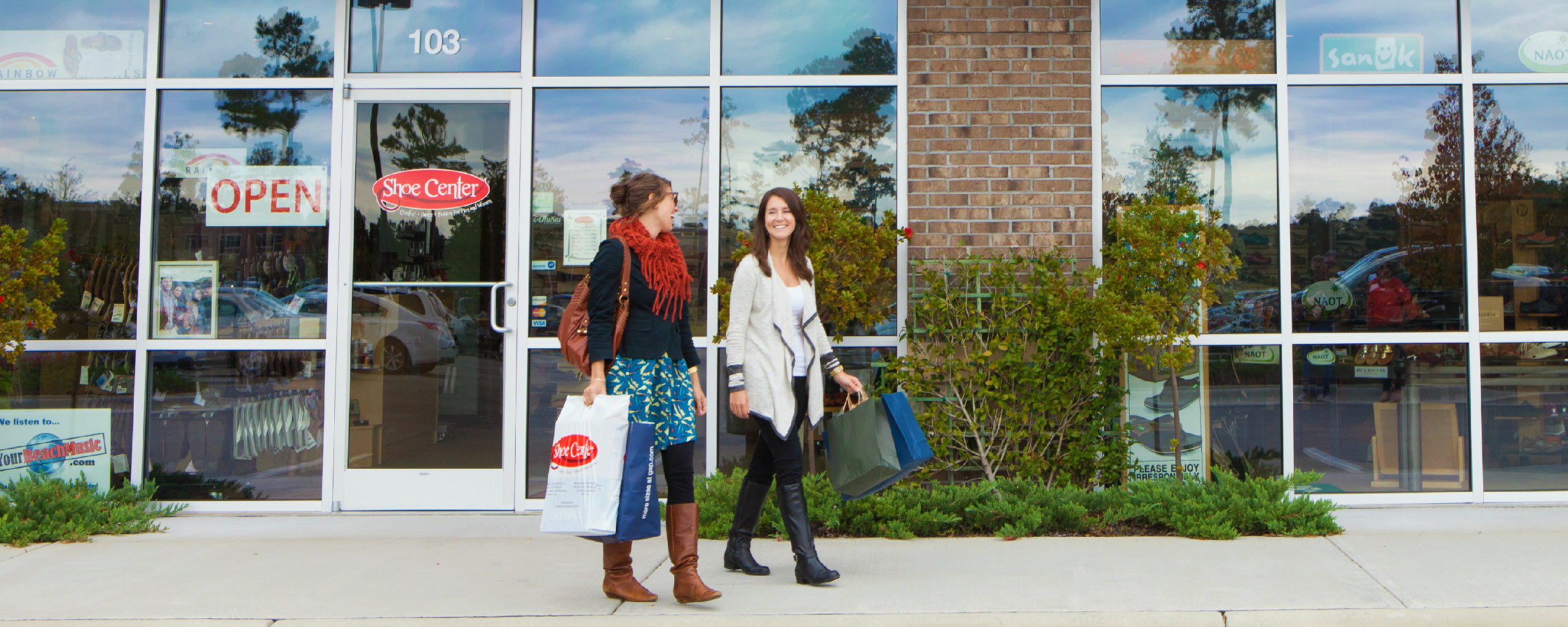 Customers with Shoe Center bags leaving the store